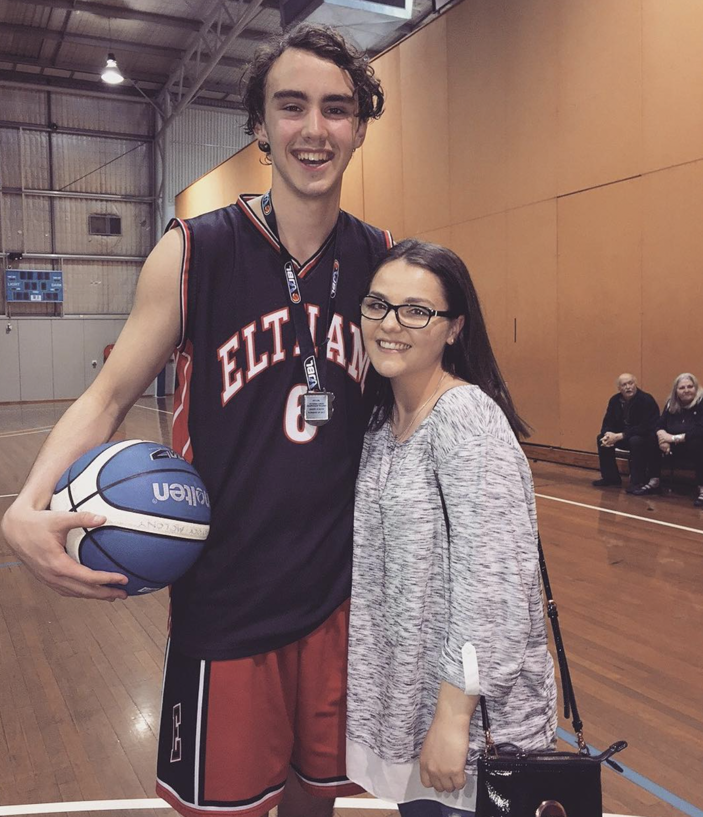 Young Pat Molony in Eltham #6 basketball jersey holding a blue Molten ball on the court